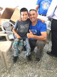 Pastor Elmer giving shoes to small child